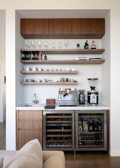 a kitchen with open shelves filled with wine bottles