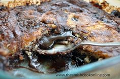 baked chocolate fudge pudding in a glass dish with a spoon and title above it