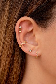 a woman wearing three star shaped ear piercings