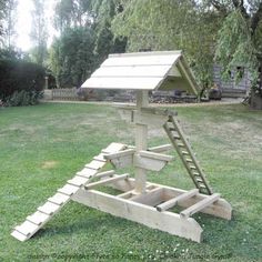 a wooden structure with stairs on the grass