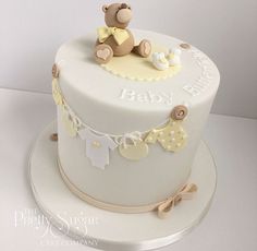 a baby shower cake with a teddy bear on top