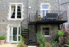 a stone building with two balconies on the second floor and stairs leading up to it