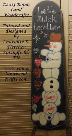 a snowman is painted on the back of a skateboard that says let's stick together