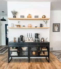 a kitchen area with shelves, coffee maker and other items