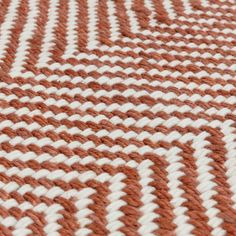 an orange and white rug is shown in close up