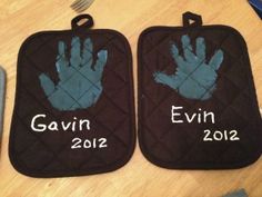 two oven mitts with handprints on them sitting next to a knife and fork