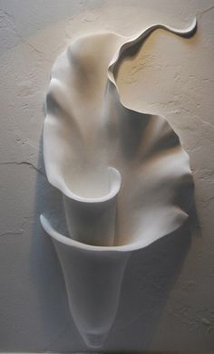 a white vase sitting on top of a wall