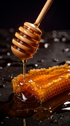 honey dripping from a wooden spoon into a glass container