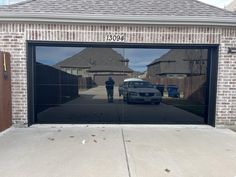 a car parked in front of a garage door with the reflection of two people on it