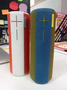 two blue and red speakers sitting on top of a white table next to each other