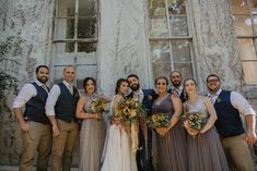 a group of people standing next to each other in front of a building with windows