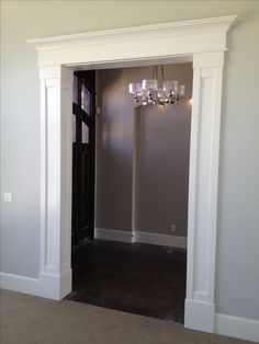 an empty room with a chandelier hanging from the ceiling