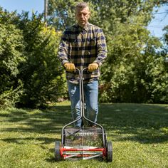 a man mowing the grass with a lawnmower