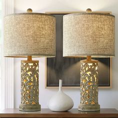 two lamps sitting on top of a wooden table