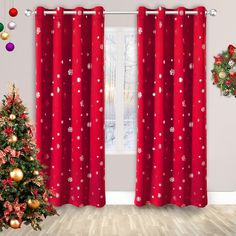 a christmas tree in front of a red curtain with snowflakes and stars on it