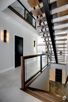 an open staircase with glass railings and wooden handrails in a modern home