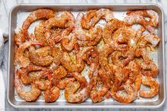 cooked shrimp in a baking pan on a marble counter top, ready to be served