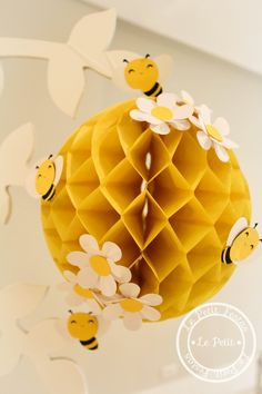 a honeycomb with paper flowers and bees hanging from it