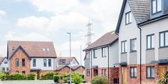 a row of houses with cars parked on the street