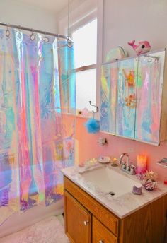 a bathroom with a sink, mirror and shower curtain covered in holographics