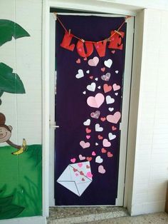 a door decorated with paper hearts and an origami monkey hanging from it's side