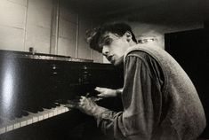 black and white photograph of man playing piano