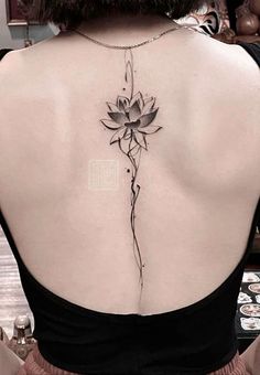 a woman's back with a flower tattoo on it