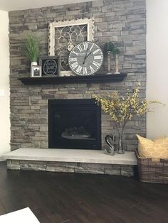 a living room with a stone fireplace and clock on the mantle