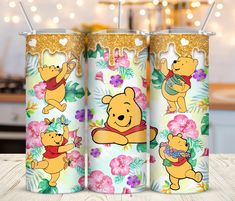 three disney winnie the pooh tumblers with straws in them on a table