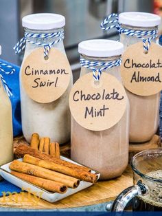 cinnamon and chocolate flavored milks are on display in glass jars with tags that say,