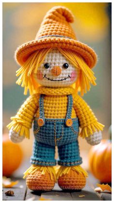 a crocheted scarecrow doll with oranges in the background