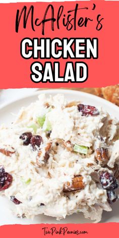 chicken salad on a white plate with cranberries and pecans in the background