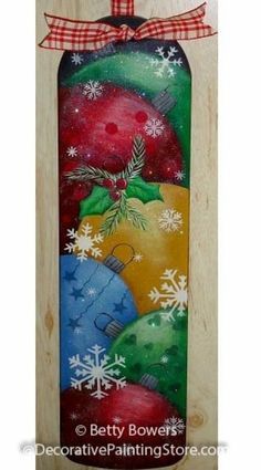 a wooden door hanger decorated with christmas ornaments and snowflakes on it's side