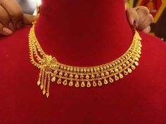 a gold necklace is being displayed on a mannequin's neckline at a jewelry store