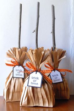 three bags with tags tied to them sitting on a table next to some sticks and twig