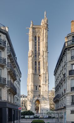 a tall building with a clock on it's side in the middle of a city