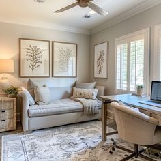 a living room filled with furniture and a laptop computer on top of a wooden desk