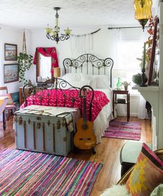 a bed room with a guitar on the floor and a rug in front of it