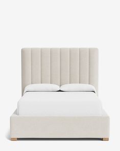 a white bed with two pillows on top of it