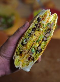 a hand holding a taco filled with lots of toppings