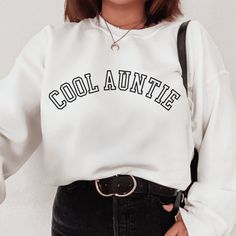 Introducing the perfect addition to any Aunt's wardrobe: the Cool Auntie sweatshirt! Not only is this sweatshirt fashionable, but it's also practical. Whether you're running errands, picking up the kids from school, or just lounging around the house, the Cool Auntie sweatshirt is the perfect choice. It's versatile enough to pair with leggings, jeans, or even your favorite joggers, making it a must-have for any mom on-the-go. It also makes for a great birthday gift for the coolest aunt in your life. So why wait? Treat yourself or a special aunt in your life to the stylish and cozy Cool Auntie sweatshirt today! ♥ Ideal for any situation, a unisex heavy blend crewneck sweatshirt is pure coziness. These garments are made from polyester and cotton. This combination helps designs come out lookin Auntie And Nephew Shirts, Aunt Things, Aunt Baby Announcement, Auntie Sweatshirt, Promoted To Auntie, Aunt Baby, Baby Aunt, Teacher Fashion, Aunt Shirt