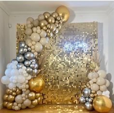 a gold and silver party decoration with balloons