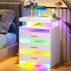 a white night stand with colorful lights on it