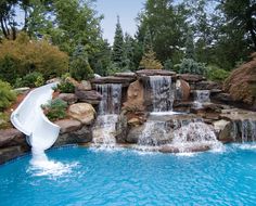 a pool with a waterfall and slide in it