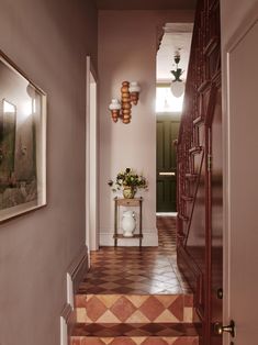 an entry way with stairs and potted plants on the side table next to it