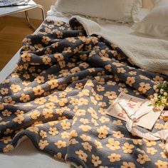 a bed with a blanket and flowers on it