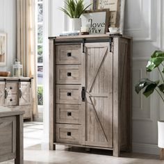 a wooden cabinet sitting in a living room next to a potted plant