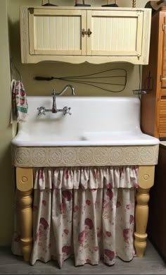 a white sink sitting under a bathroom mirror next to a wooden cabinet and counter top