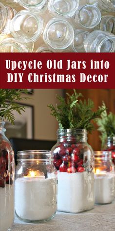 jars filled with christmas decorations and candles on top of a white tablecloth covered counter