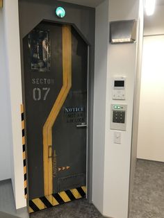 the door to an elevator is open with yellow and black stripes